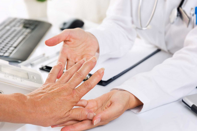 Rheumatische Erkrankungen der Weichteile - Ein Arzt untersucht die Hand eines Patienten, um gesundheitliche Probleme festzustellen.