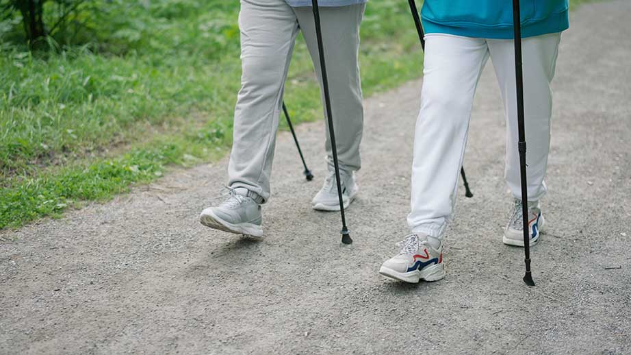 Zwei Menschen gehen mit Gehstoecken nebeneinander